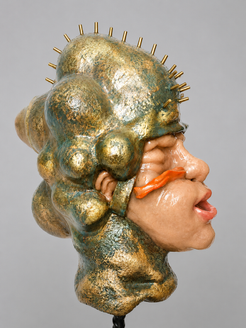 Seitlich dargestellte figurative Plastik mit gold-grün schimmernder organischer Kopfform und kleinen metallischen Stiften auf der Oberfläche. Eine leuchtend orangefarbene Form zieht sich über das geschlossene Auge der Figur. Der Kopf sitzt auf einer schmalen Verbindung über einem spiralartig aufgebauten Körperfragment auf steinfarbenem Sockel. Die glänzende Oberfläche verbindet technische und körperhafte Elemente zu einer post-sakralen, surrealen Wirkung vor hellem Hintergrund.