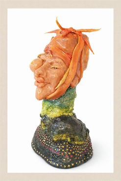 Seitenansicht einer Büste mit orangefarbenen, wurmartigen Formen auf dem Kopf, einem seitlich hervortretenden runden Auge mit gelber Öffnung, grünem Hals und dunkel gepunktetem Sockel.