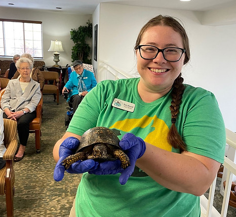 Mini-grant winner holds up a box turtle while teaching at a senior living facility.