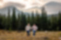 Engaged couple holding hands during a Colorado engagement session at Brainard Lake with pine forest and mountain views in the background