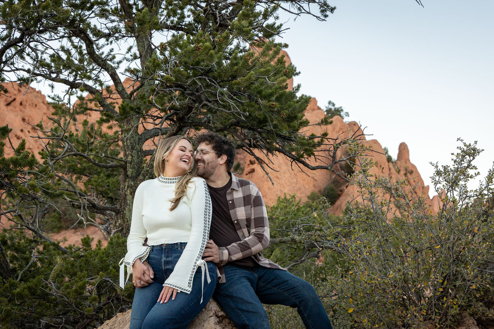Couple walking toward camera with red rocks and mountains behind them