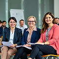 professional development education field women sitting with colleagues holding notebook.j