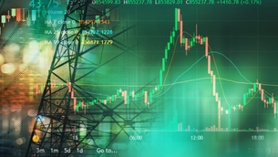 Stock market graph overlaid on a city skyline with bright lights. Green and red candlesticks with technical indicators and numbers visible.