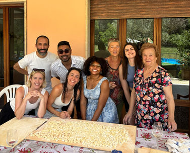 Nesting Away coliving guests with Nonna Maria celebrating after making over 1000 gnocchi together at the villa in Orte, Italy