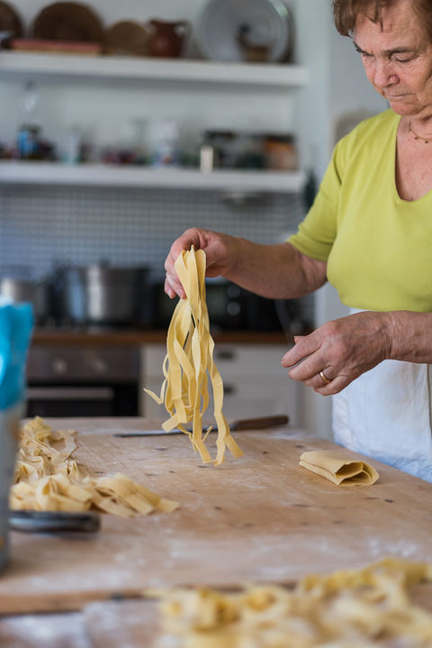Nonna Maria teaching pasta making class at coliving Italy showing authentic traditional Italian cooking