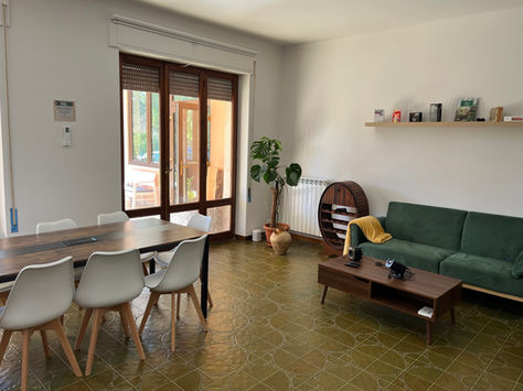 Living room with couches and table inside a coliving in Italy near Rome.