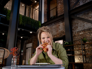 Rachael with a cheeky face biting a croissant