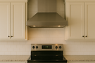 Stainless steel range hood above electric cooktop