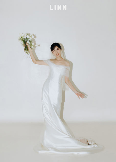 經典棚拍婚紗：新娘優雅側坐在白色沙發，展現婚紗長裙擺的流動質感與簡約構圖。