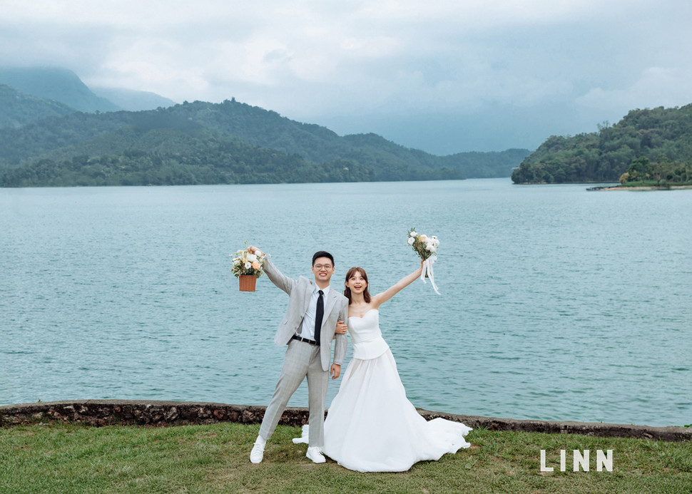 

Wedding couple cheering with bouquet at Sun Moon Lake by LINN Photography.