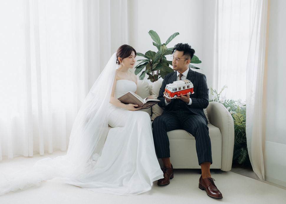 中： 新郎新娘在簡約棚拍中一起翻閱書籍，展現知性且優雅的法式生活風格。


英： Couple reading a book together in a minimalist studio, intellectual French wedding style.