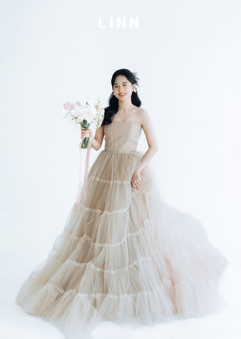 新娘提裙擺動態特寫，燕麥色蛋糕婚紗律動感。 


 Dynamic shot of bride holding her oatmeal dress, playful vibe.