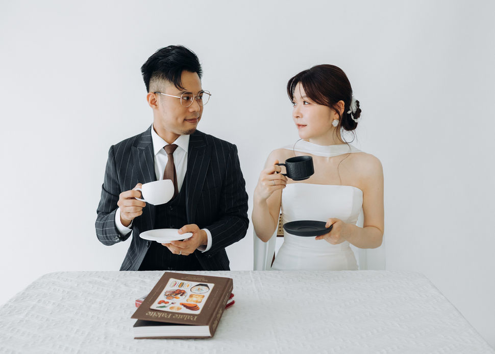 EN: Couple looking at each other across a table with coffee cups, symmetrical and intimate.