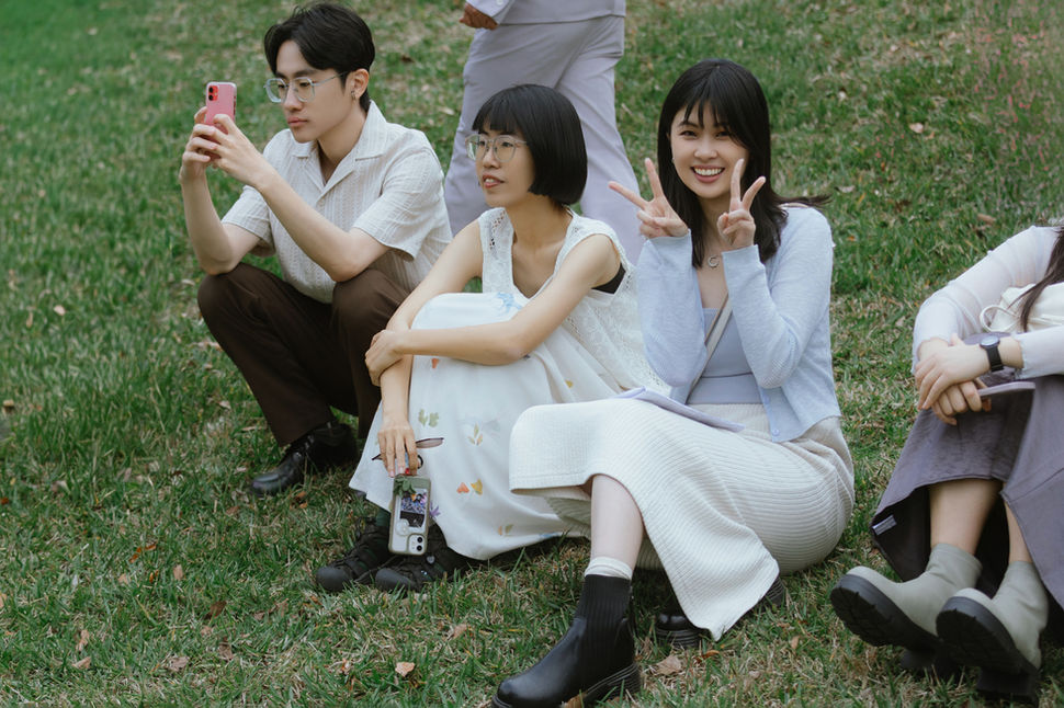 南窩綠丘,婚禮賓客坐在草地上歡笑。