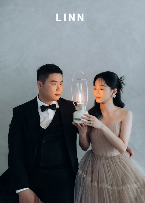 新人共持露營燈婚紗，燕麥色禮服暖色調攝影。 


 Couple holding a camping lantern together, warm studio light.