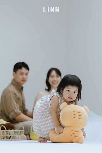 美式家庭寫真中幼兒抱著玩偶,背景為溫馨的居家生活感親子攝影