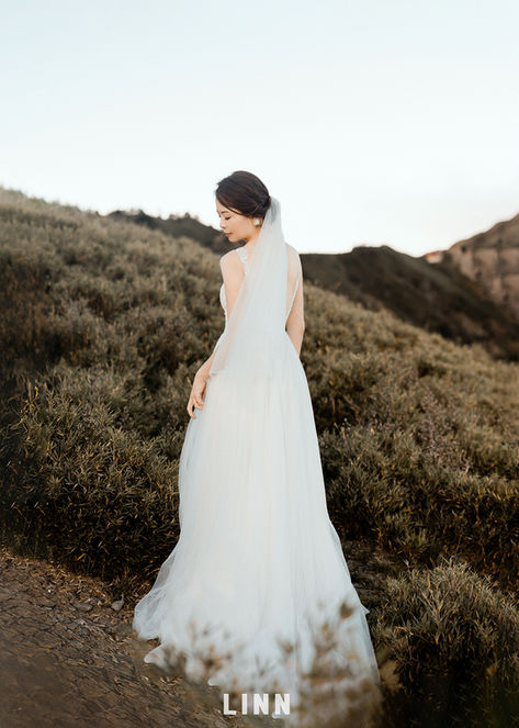 En: Against the grand mountains, capturing your most elegant, timeless silhouette.