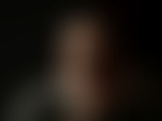 a-woman-wearing-glasses-sitting-in-a-dark-room