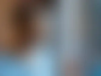 Person in blue hospital gown standing by window