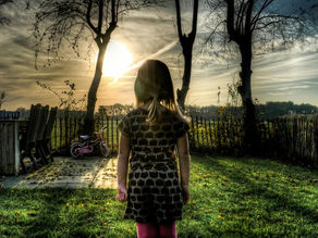 a child in her backyard at dusk