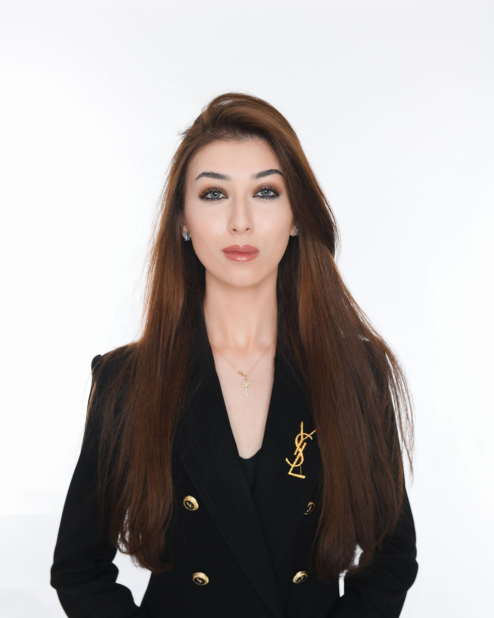 The image shows a professional headshot of a woman with long, dark brown hair wearing a black blazer. She has a confident and poised expression, with her gaze directed at the camera. The image would be suitable for use in a corporate or business context, such as a website, social media profile, or marketing materials.