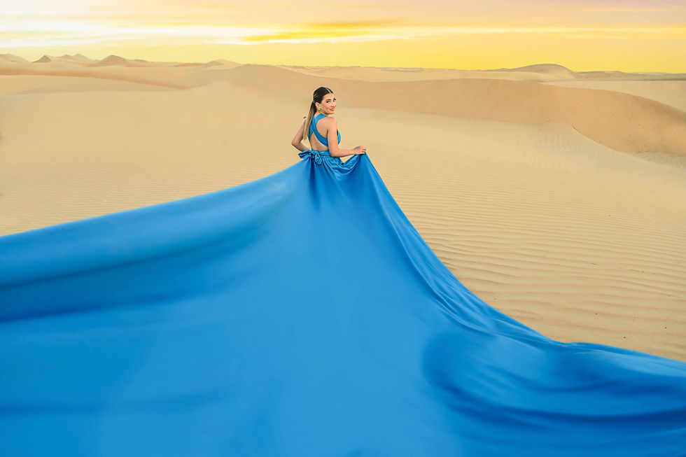 A womenenjoying the flying Dress Photoshoot in the blue flying Dress walking in the golden sand and sun as the backdrop