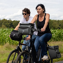 Lenkertasche Maxi Plus in grau und schwarz jeweils am Lenker am Rädern, mit denen eine Frau und ein Mann fährt