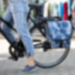 Einzeltasche blau in Jeans-Optik mit schwarzem Steckverschluss und Tragegriff,  am Fahrradgepaecktraeger, Nahaufnahme