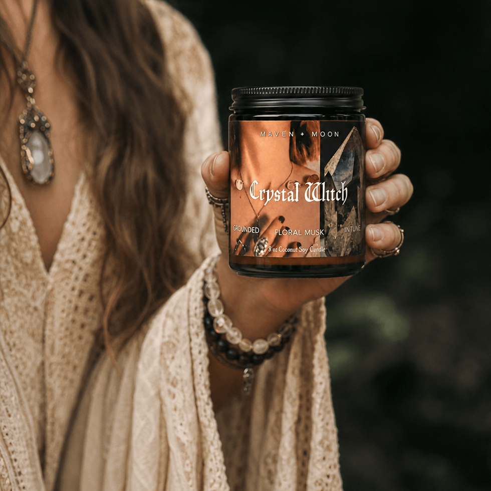 Thumbnail: Person holding Crystal Witch candle in an amber apothecary jar while wearing layered crystal jewelry and flowing cream lace i
