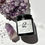 Thumbnail: close up of a black matte jar with a shimmer lotion containing swirling colors of deep lavender, soft pink, and mica silver