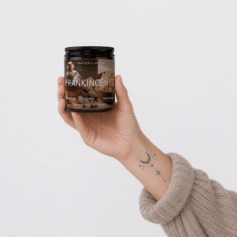 Thumbnail: Hand holding MAVEN + MOON Frankincense coconut soy candle against a soft warm gray background with oversized knit sweater and