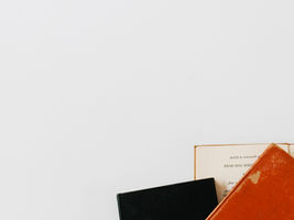 Drei Bücher am unteren Rand eines weißen Hintergrundes.