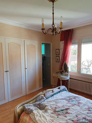 Chambre avec placards intégrés anciens et mobilier classique, avant rénovation