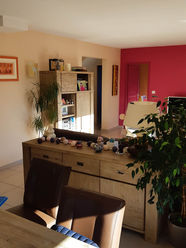 Ancien séjour vu depuis la salle à manger avec mobilier en bois.