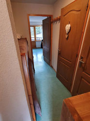 Couloir d'accès au séjour depuis l'entrée et passage devant les portes des sanitaires.