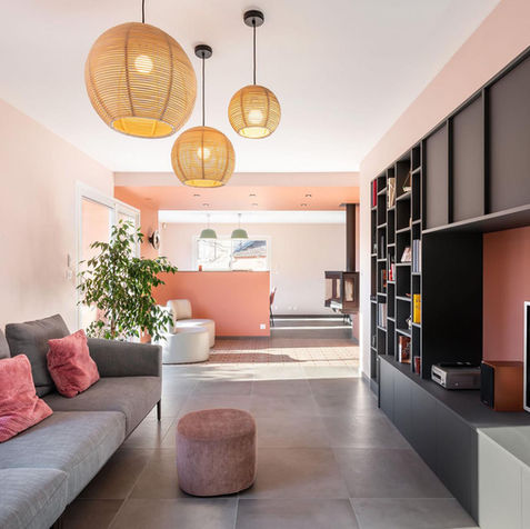 Façade noir mat du meuble TV sur mesure et canapé gris dans un salon rénové.