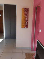 Vue sur l’entrée d’origine avec placard encastré, carrelage clair et mur coloré.