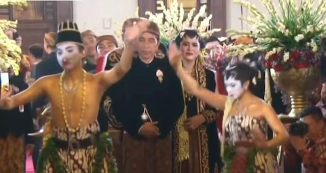 Sepasang penari di depan pengantin mengantar ke pelaminan. Bermula dari tugas suci, sekarang menjadi penggembira.