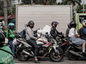 Pengendara sepeda motor mengenakan helm di kawasan Tanah Abang, Jakarta Pusat. (Fernando Randy/Historia).