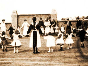 Anak-anak bermain bersama perawat tempat penitipan anak di Australia pada 1907.
