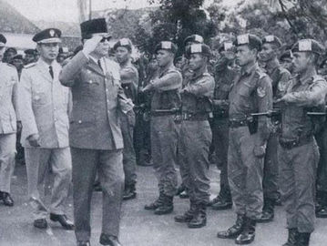 Presiden Sukarno menerima Batalyon 454 pada perayaan veteran pembebasan Irian Barat di Istana Negara, 19 Januari 1963. Di belakang Sukarno Pangkostrad Mayjen TNI Soeharto dan Mayor Untung, komandan Batalyon 454.
