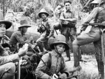 Tentara KNIL sedang rehat di tepi sebuah sungai. (Tropenmuseum).