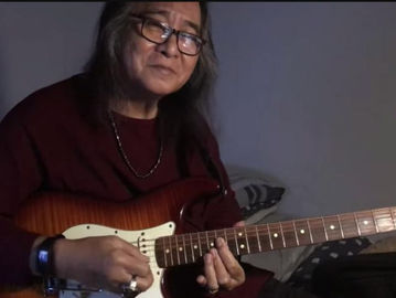 Jodie Item memetik gitar memainkan lagu Indonesia Pusaka di channel youtubenya.