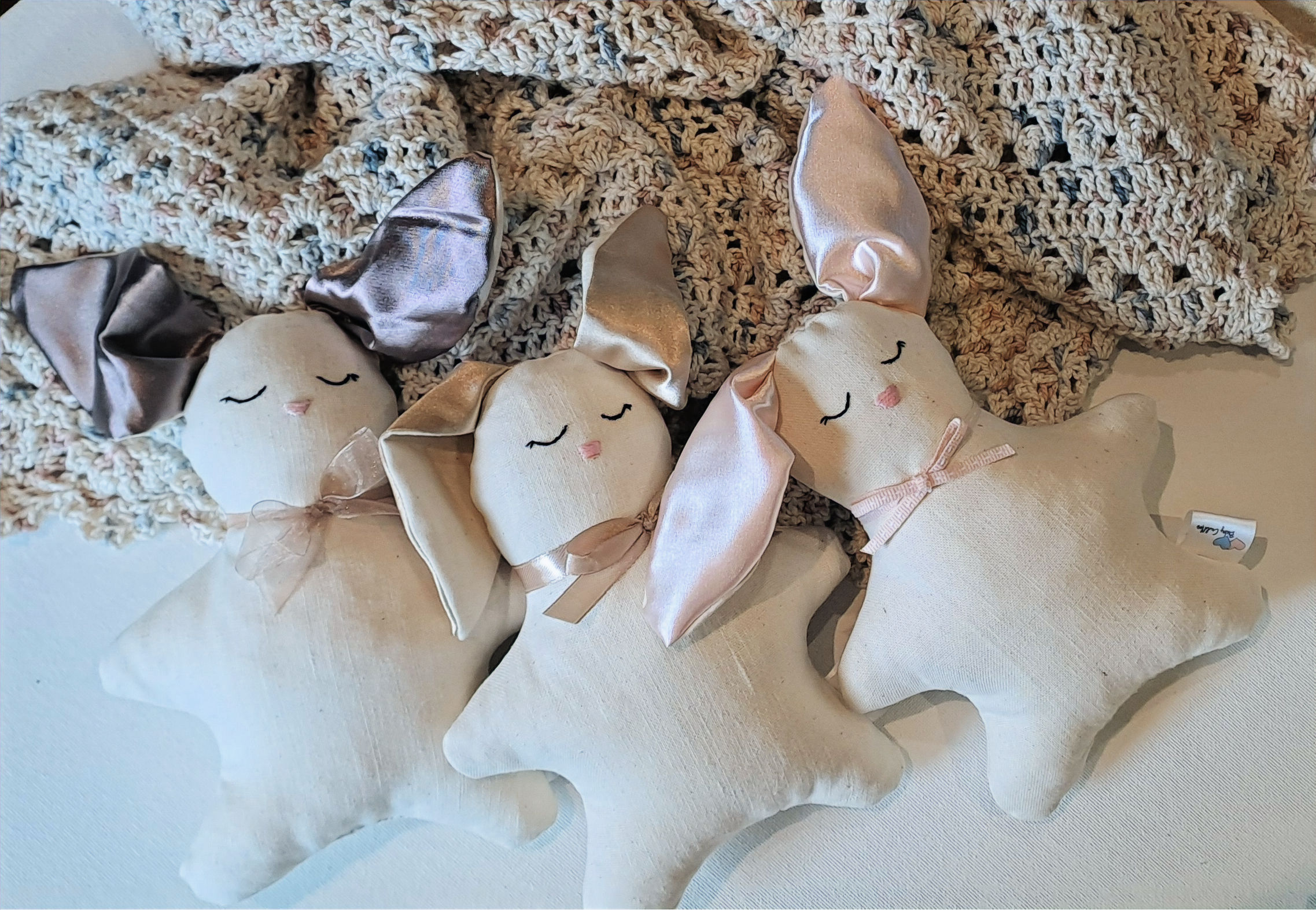 Baby cot bunnies on handmade baby blanket
