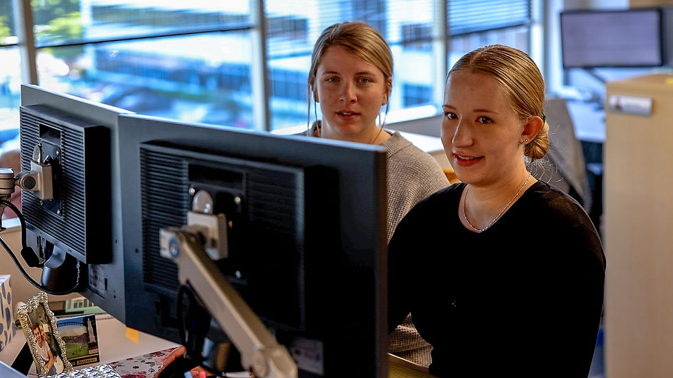 Two employees working at their computer together