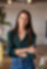 Naama stands with her arms crossed, smiling
