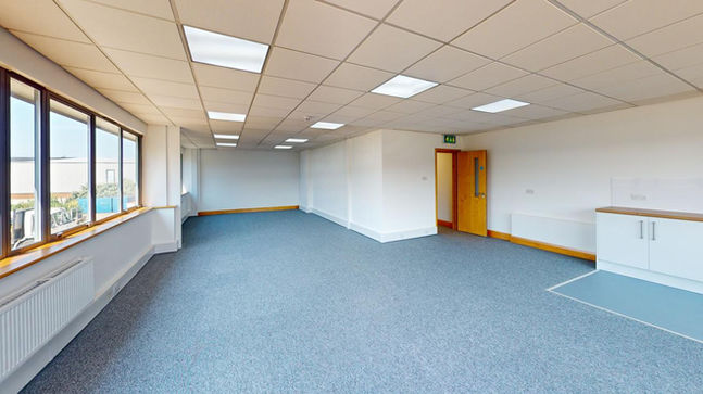 Empty office suite with blue carpet and ceiling tiles