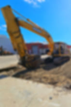 Excavator digging dirt at a construction site during site preparation