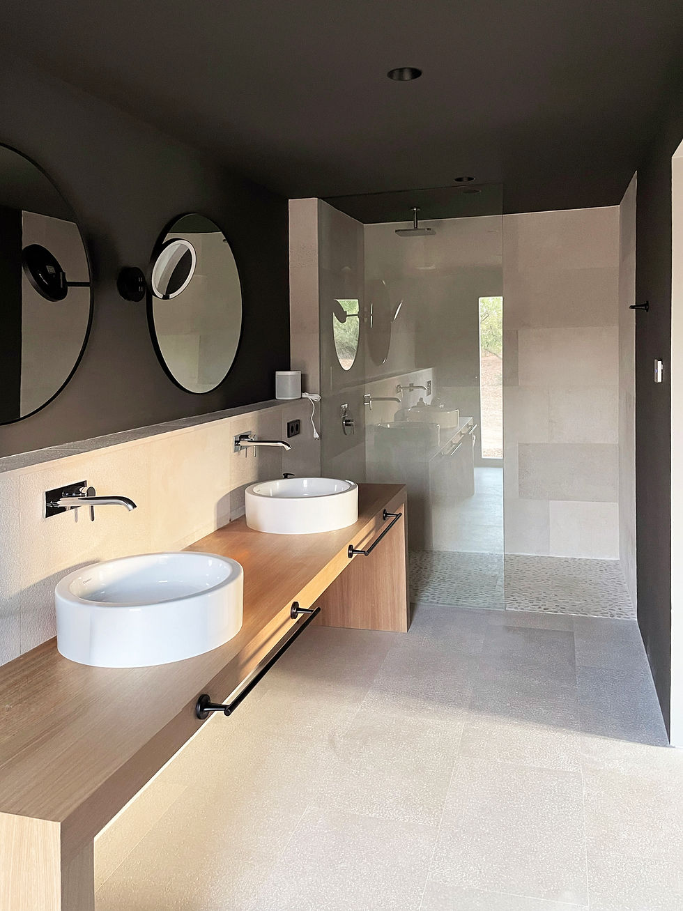 Modern bathroom with round mirror and stone basin, Finca Ponderosa, Biniali, Mallorca