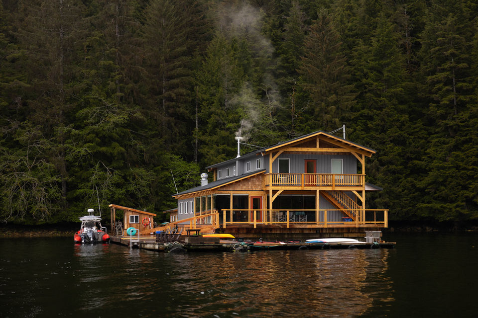 View of the Khutzeymateen Wilderness Lodge from the water, showcasing the lodge’s serene setting surrounded by the lush wilderness.